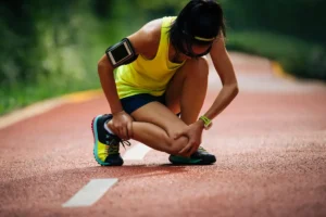 athlete bending her knee due to possible pain.