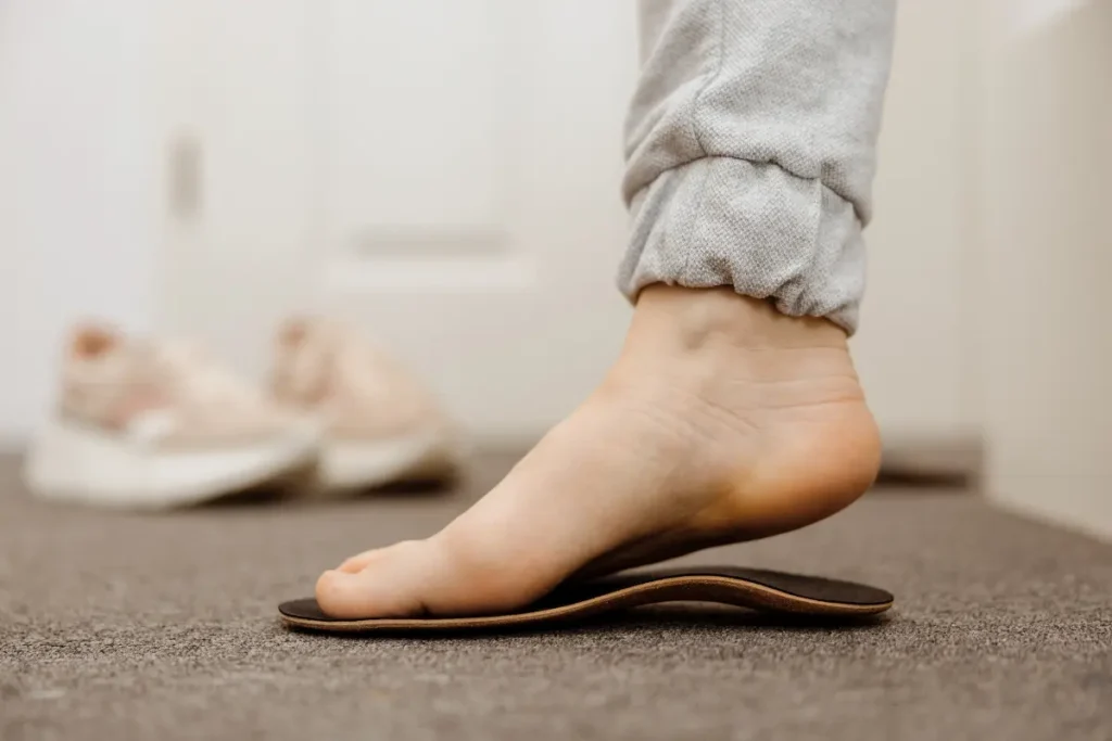 A person standing on one foot on a shoe sole.