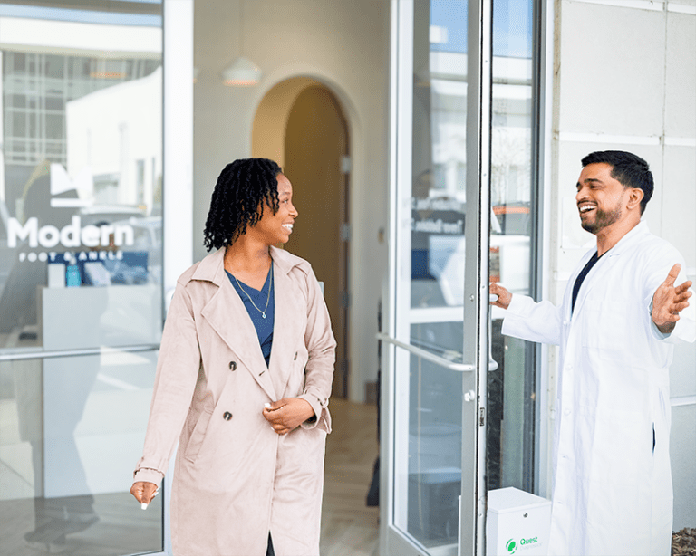 Modern Foot & Ankle doctor opening the door for a patient to the front of the office