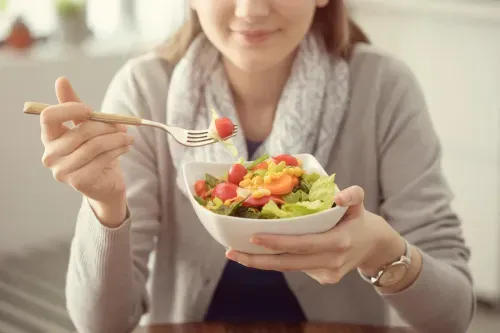 Woman eating a salad as a food that reduces swelling in feet and ankles