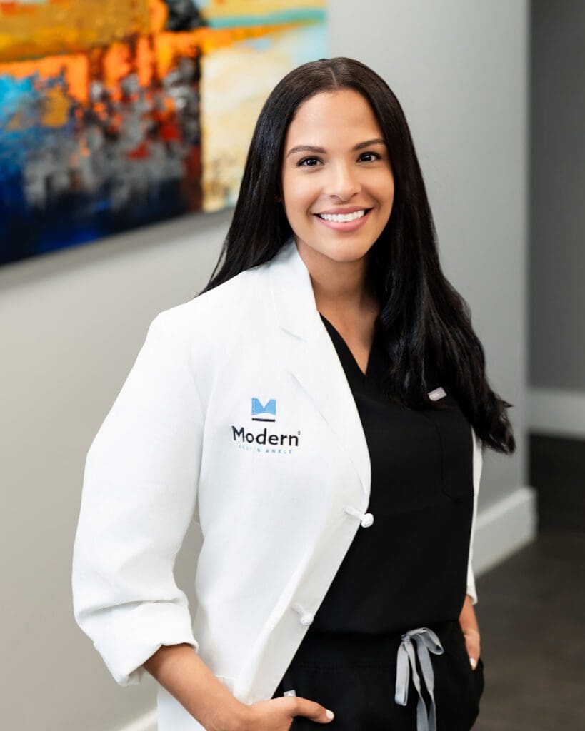 Image of Dr. Elaine Felix, a female podiatrist in Kissimmee and Lake Nona, Florida, wearing a white coat with hands in pockets.