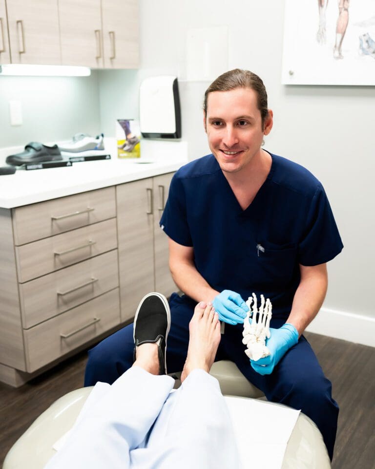 Dr. Patrick Derby, a male podiatrist in Tampa and St. Petersburg, Florida, examining a patient's foot in clinic